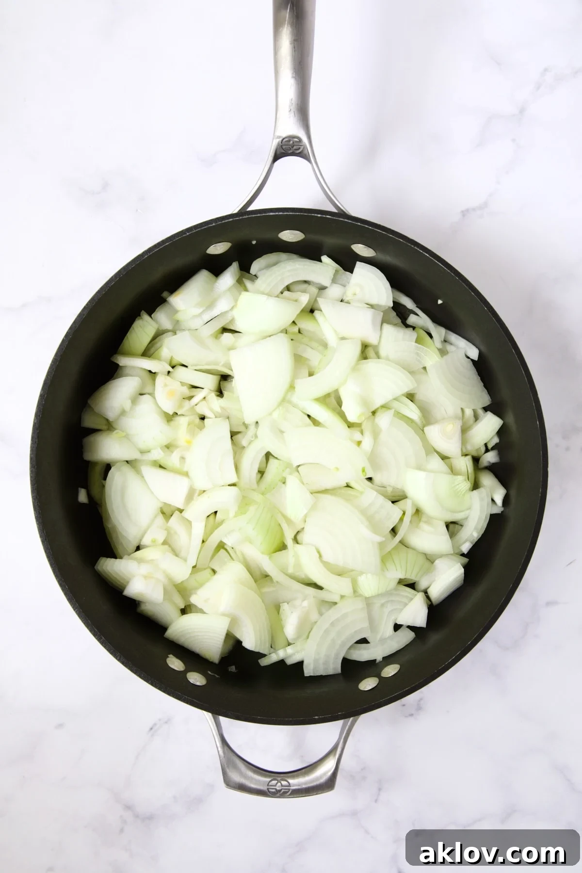 Raw, thinly sliced onions in a nonstick skillet, beginning to soften.