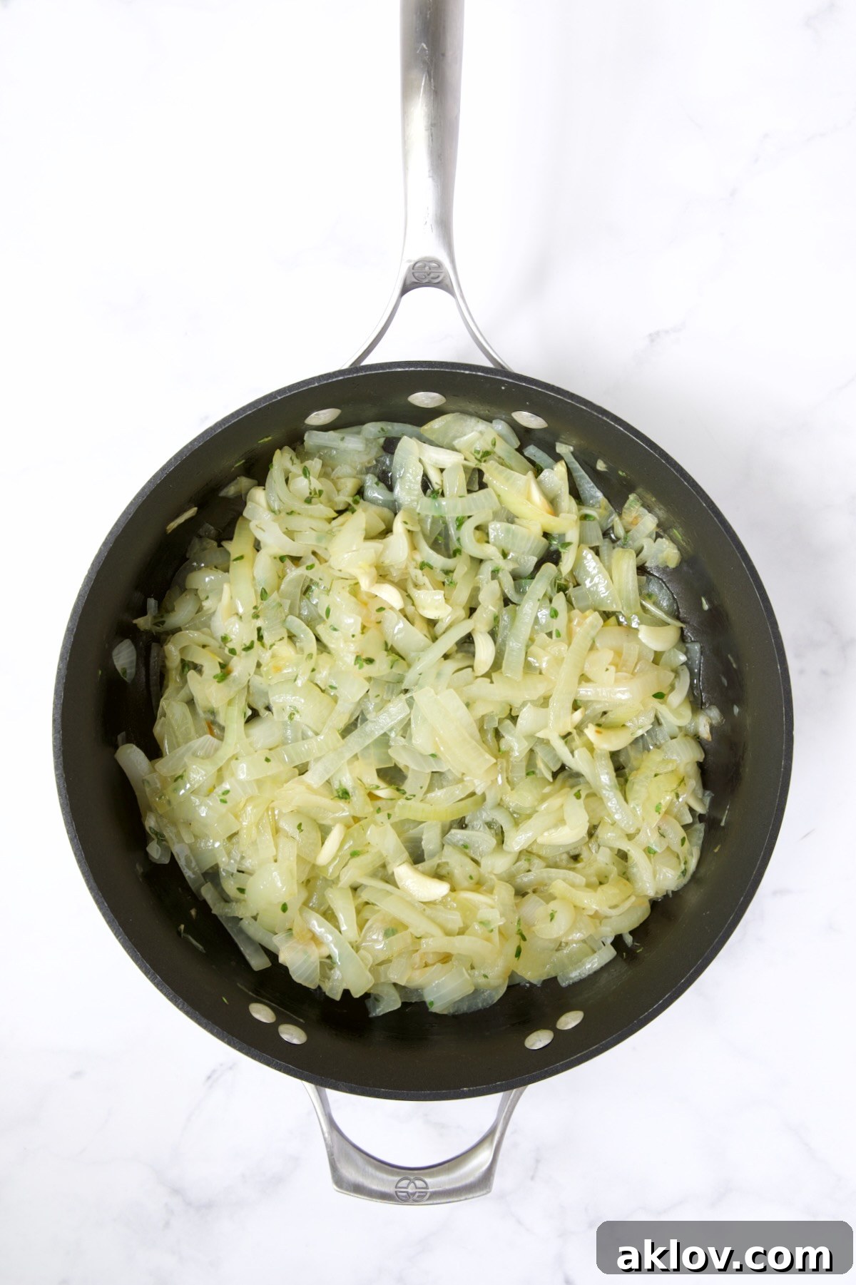 Cooked onions with garlic and fresh thyme added in nonstick skillet.
