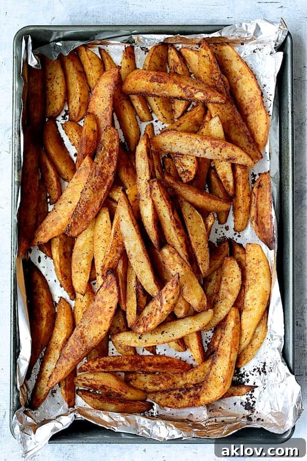 Crunchy Old Bay Wedges, Smothered in Vermont Cheddar 7 A single sheet pan filled with golden, crispy roasted potatoes, highlighting their rich texture and appealing color.