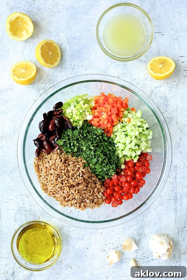 A selection of fresh, chopped ingredients for Mediterranean Farro Salad neatly arranged in glass mixing bowls.