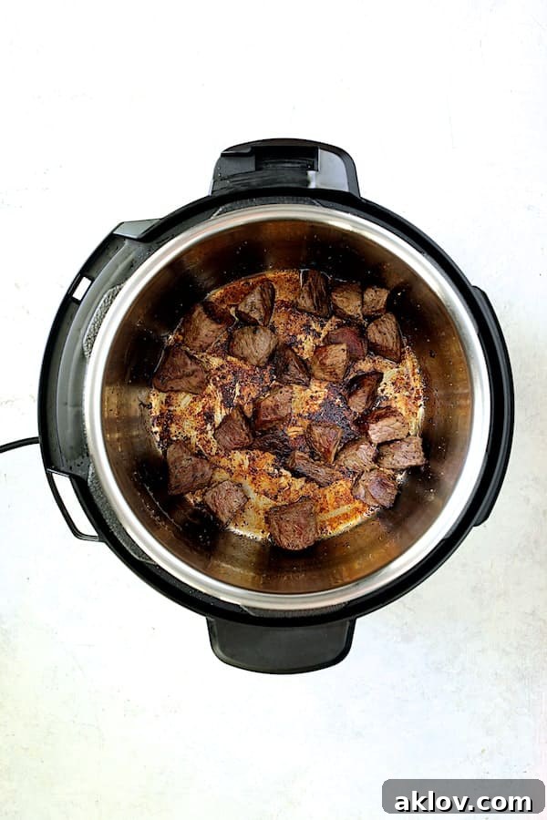 Close-up photo of beef cubes being browned in a Fissler Multi Pot, showing the delicious caramelization.