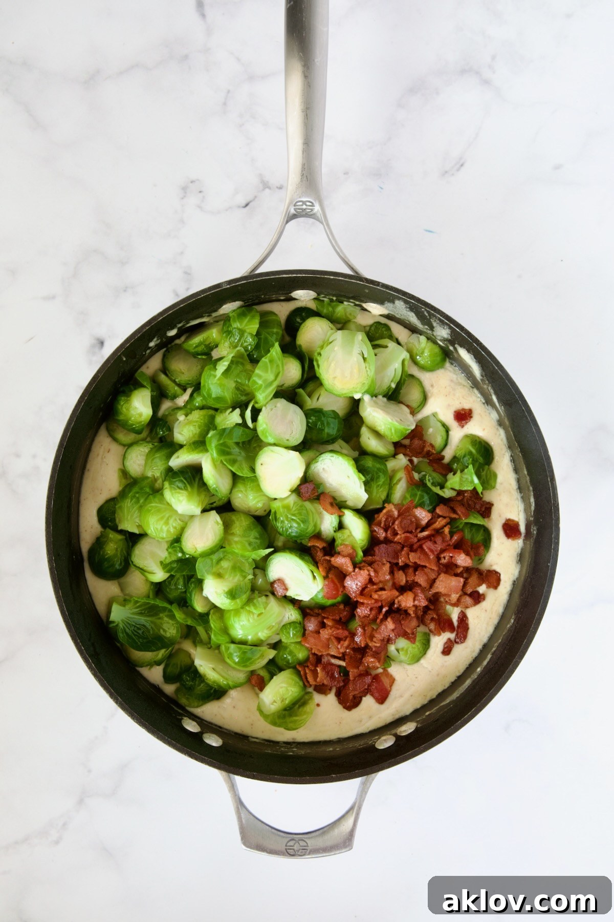 Blanched Brussels sprouts and bacon added to cheese sauce in nonstick skillet.