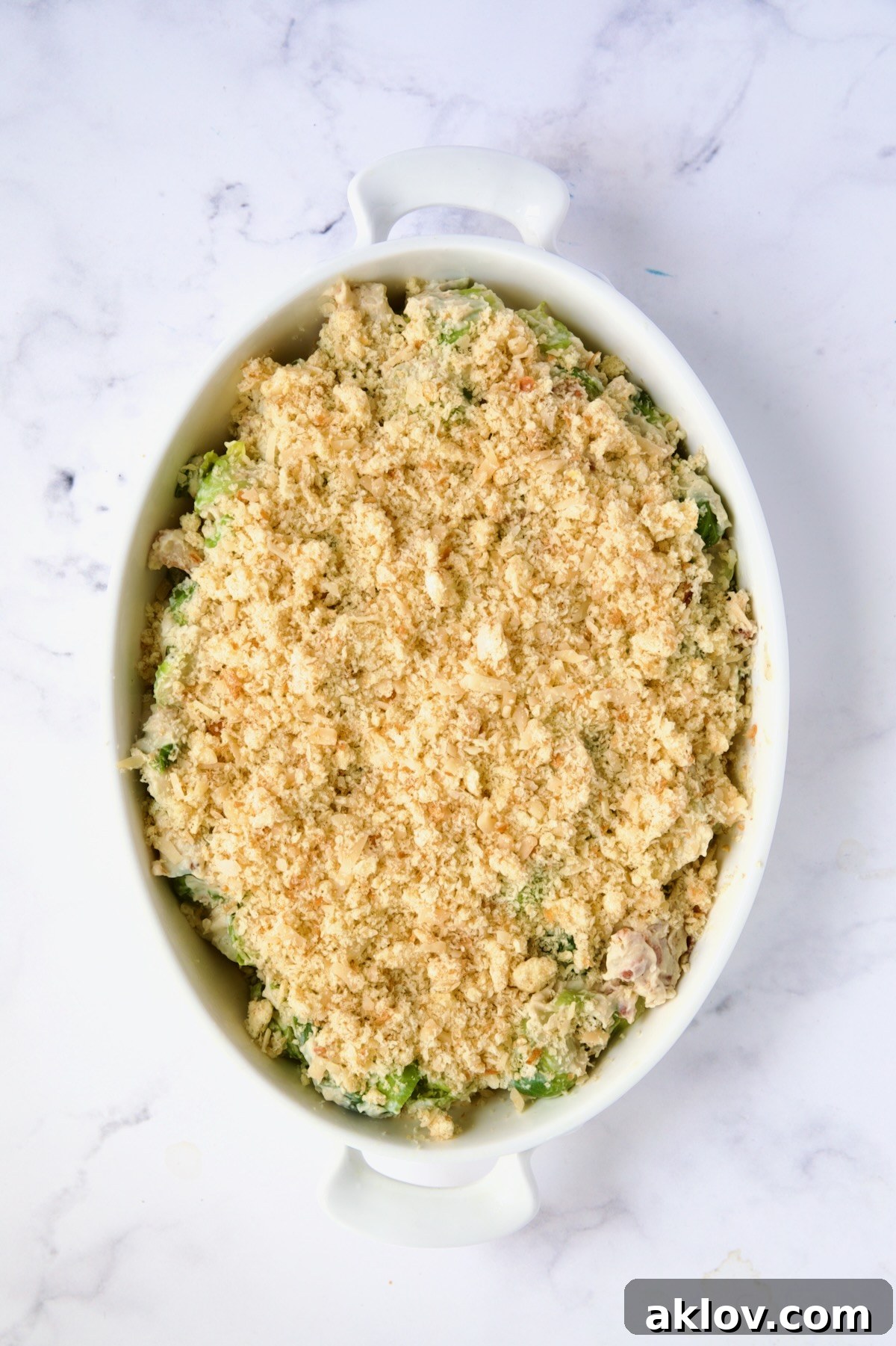 Brussels Sprouts Gratin fully assembled with breadcrumb topping in oval baking dish ready to bake.