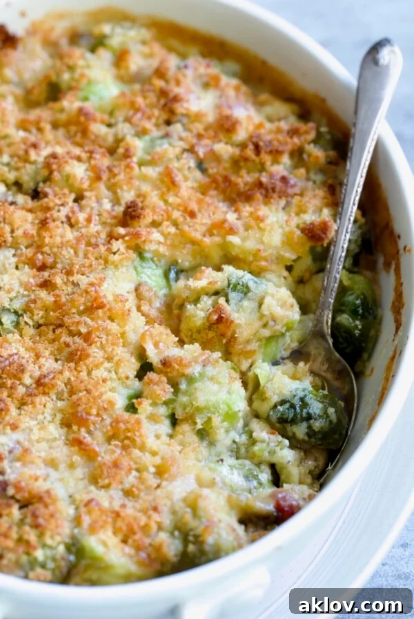 Brussels Sprouts Gratin in oval baking dish with spoon scooping some up.