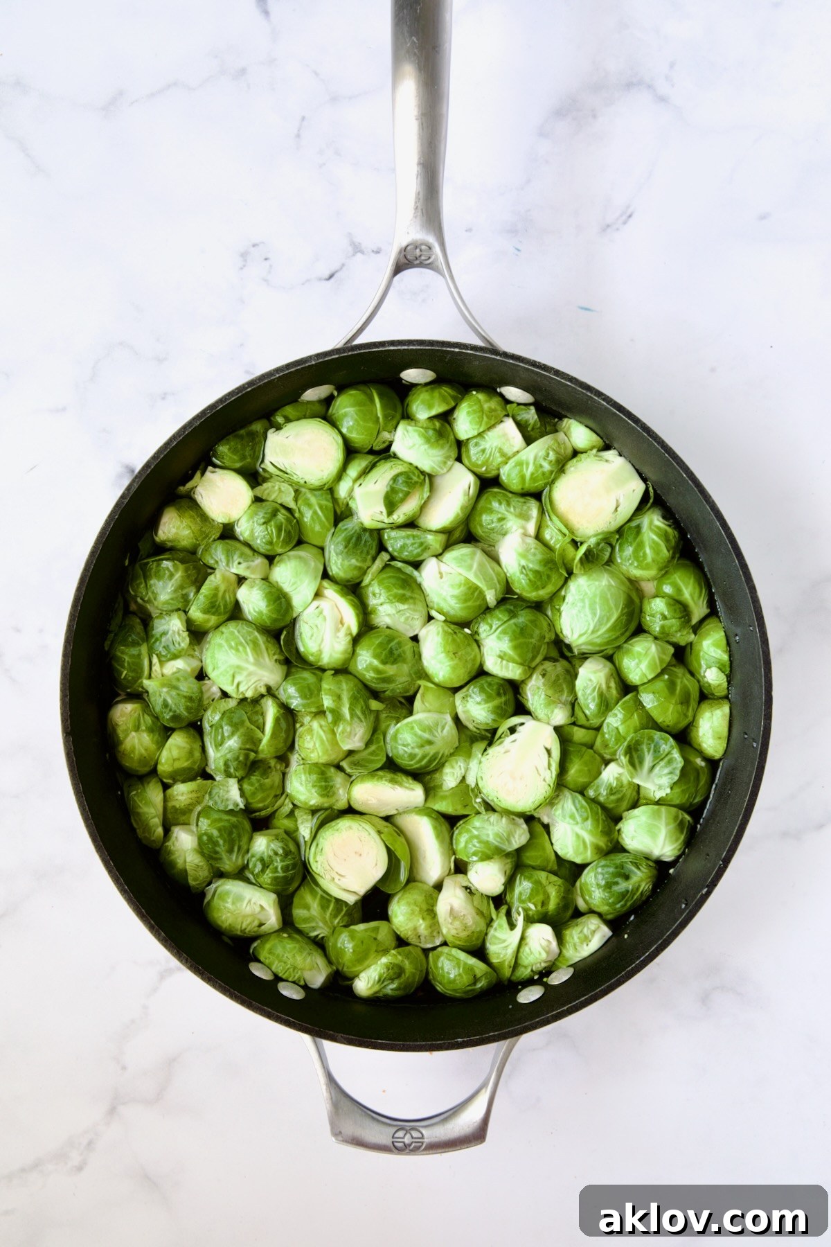 Brussels sprouts cut in half in nonstick skillet.