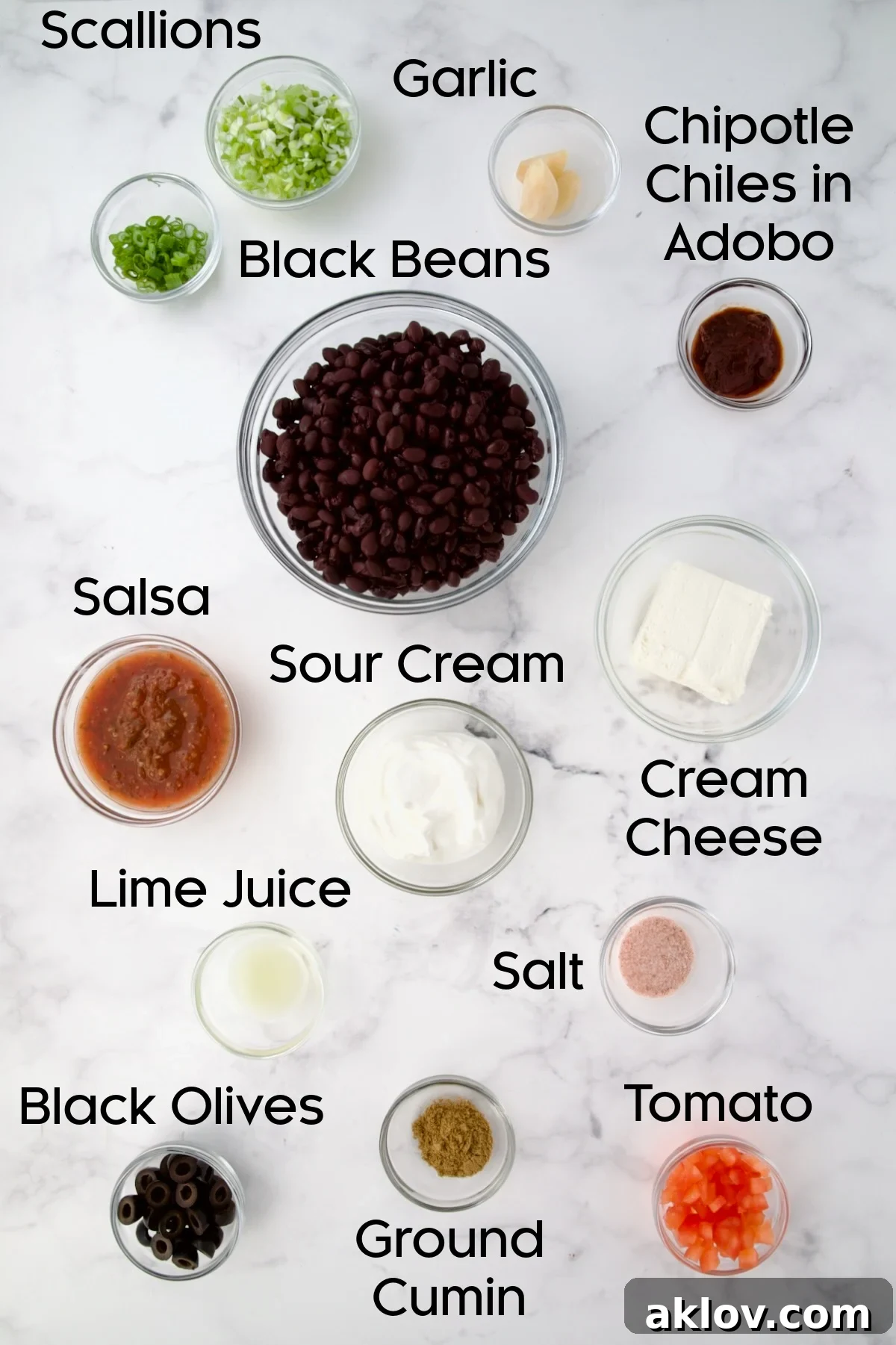Zesty Black Bean Delight 4 Individual glass bowls filled with ingredients for Black Bean Dip, including black beans, sour cream, salsa, garlic, and chipotle.