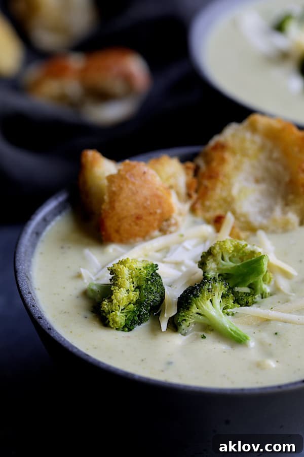Close-up shot of creamy Broccoli Gruyere Soup in a gray bowl, ready to be enjoyed.