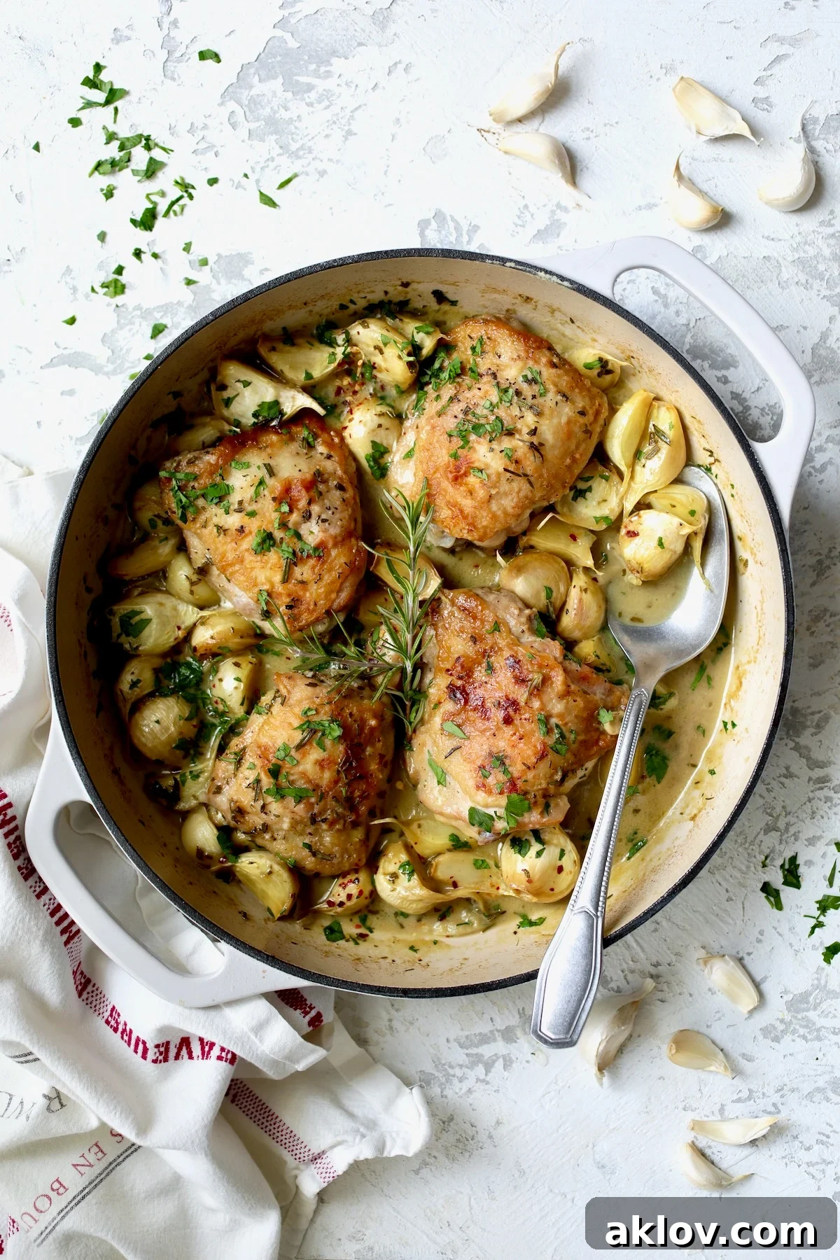 Four servings of 40 Clove Garlic Chicken in white enamel cast iron skillet.
