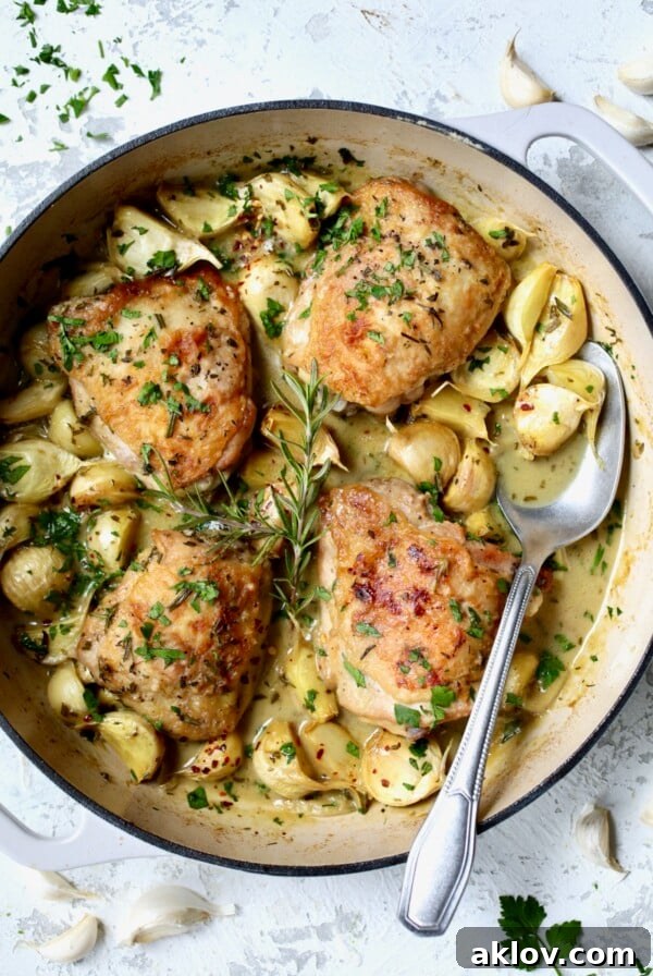 Finished 40 Clove Garlic Chicken in white enamel cast iron skillet.