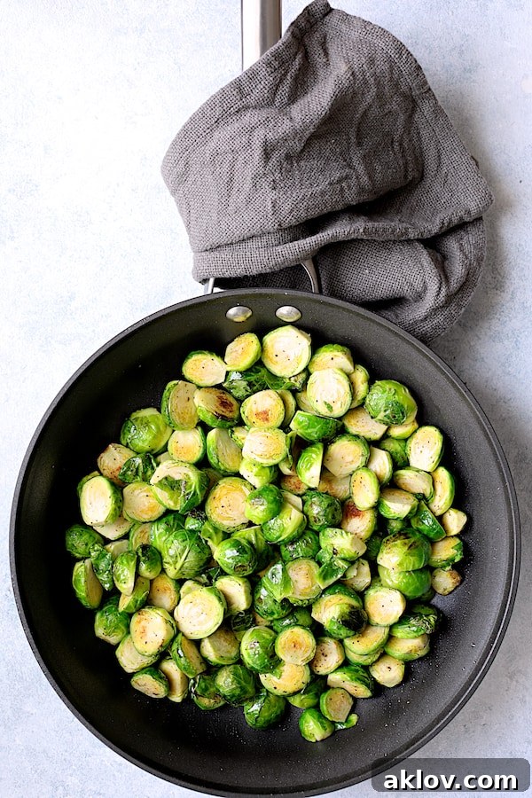Sweet Heat Orange Glazed Brussels Sprouts 4 Photo of slightly charred Brussels sprouts in a nonstick skillet, beginning to brown and soften.