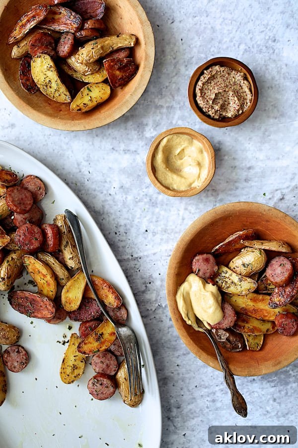 Duck Fat and Rosemary Roasted Fingerling Potatoes with Sausage, portioned into rustic wooden bowls, ready for individual servings.