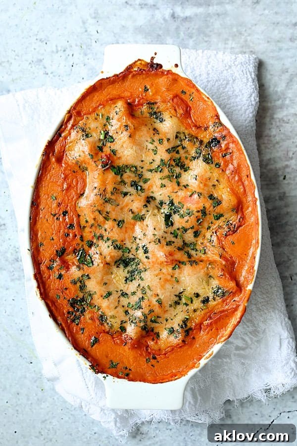 Photo of Shrimp Scallop and Artichoke Lasagna in white oval baking dish.