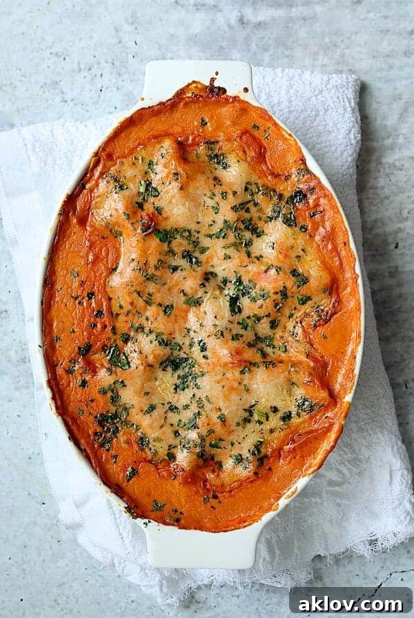 Shrimp Scallop and Artichoke Lasagna in oval white baking dish.