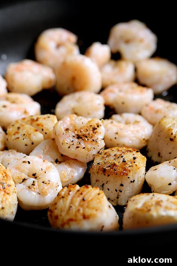 Close-up shot of seared shrimp and scallops in saute pan