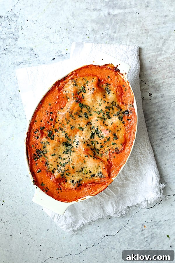 Photo of baked Shrimp Scallop and Artichoke Lasagna in white oval baking dish on white towel.