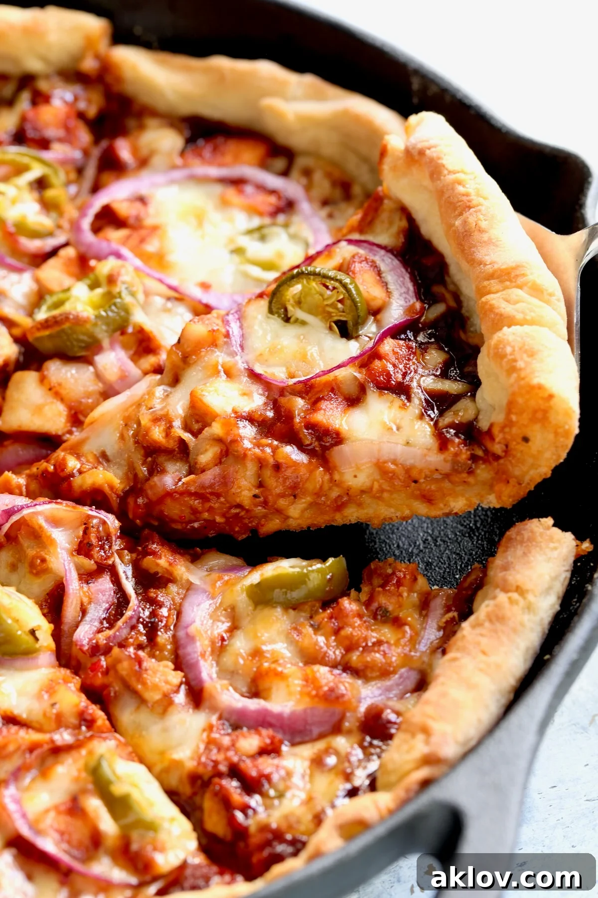 Piece of Cast Iron Skillet Pizza being lifted out of cast iron pan.