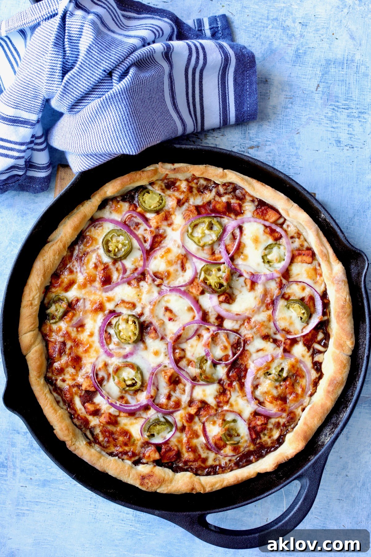 Topped pizza in cast iron skillet after being baked.