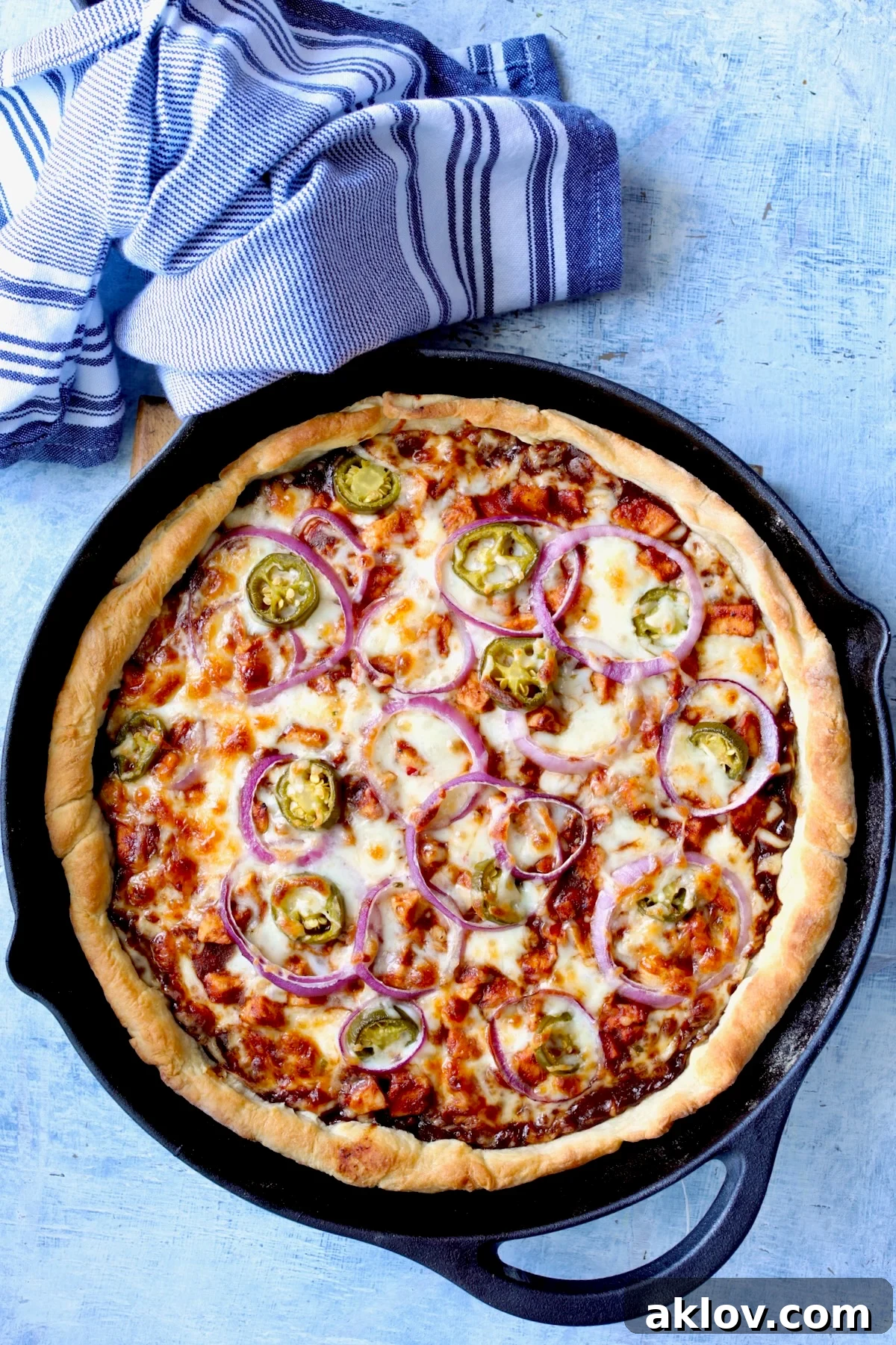 A baked cast iron skillet pizza, hot out of the oven, with perfectly melted cheese and a golden crust.
