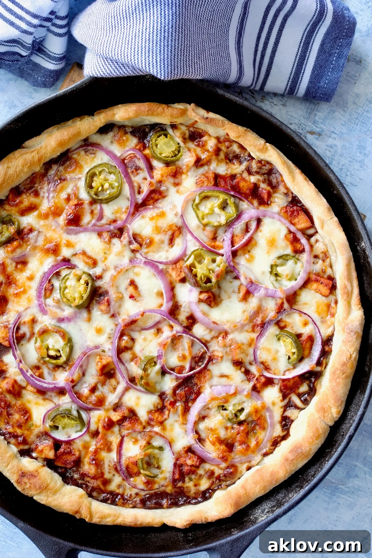 A perfectly baked whole Cast Iron Skillet Barbecue Chicken Pizza, golden and bubbling, resting in its black cast iron skillet, ready to be served.