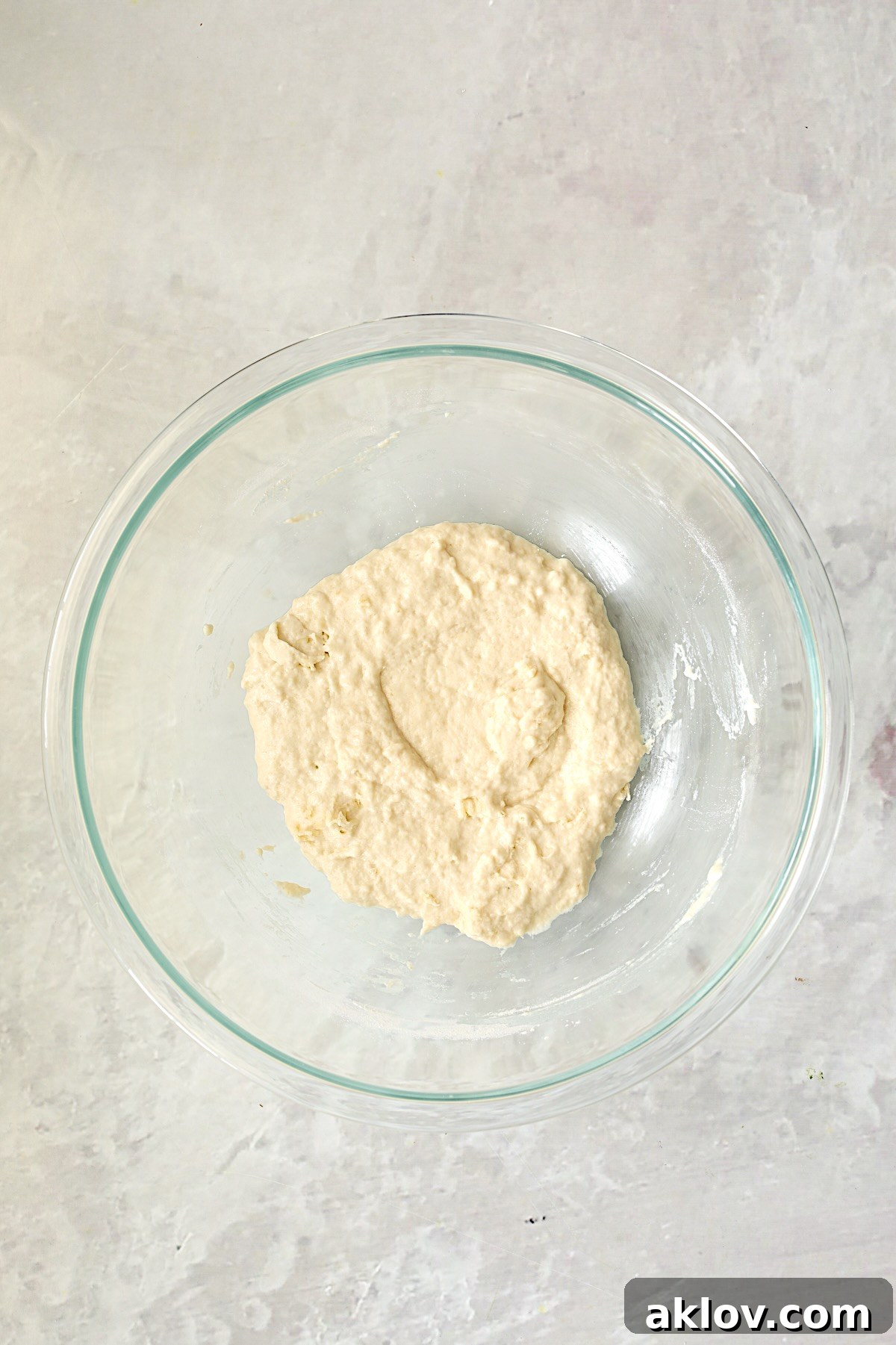 Pizza dough in glass bowl after being mixed together.