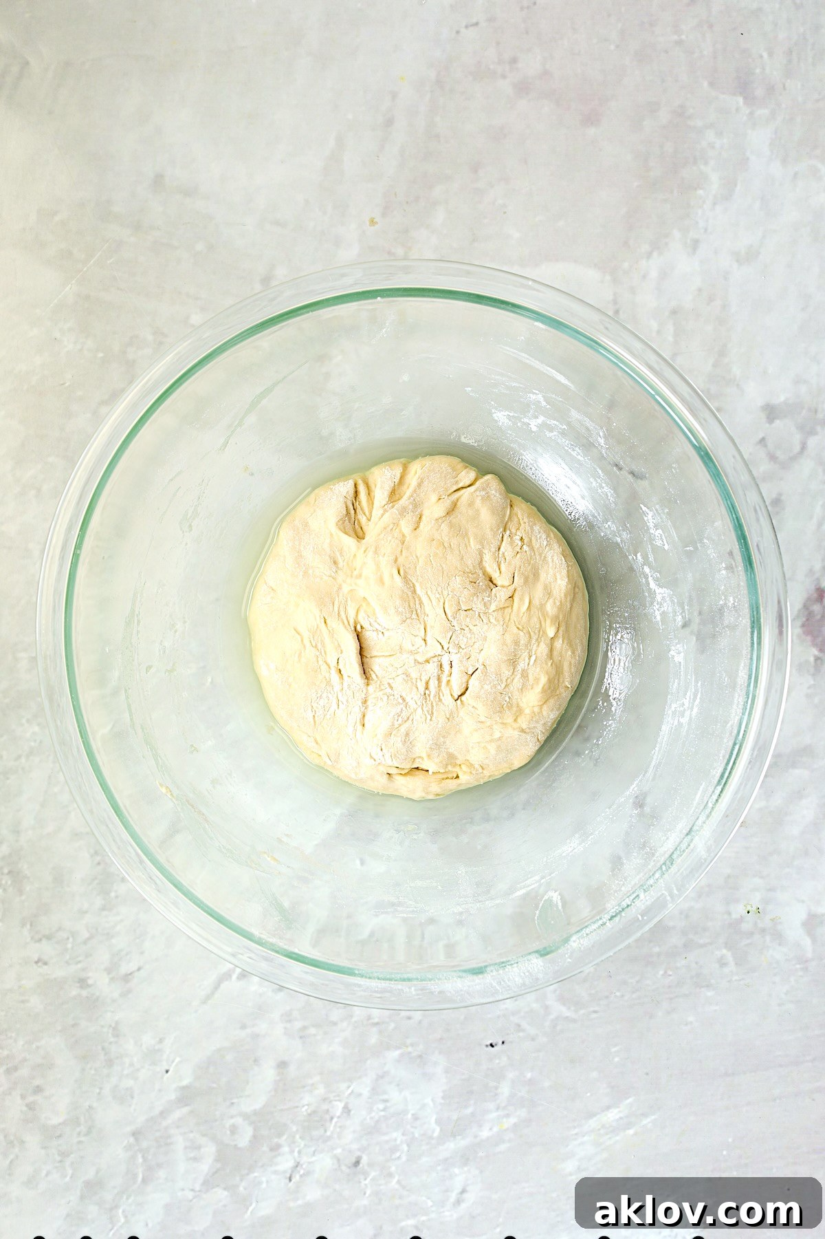 Pizza dough in glass bowl before rising.