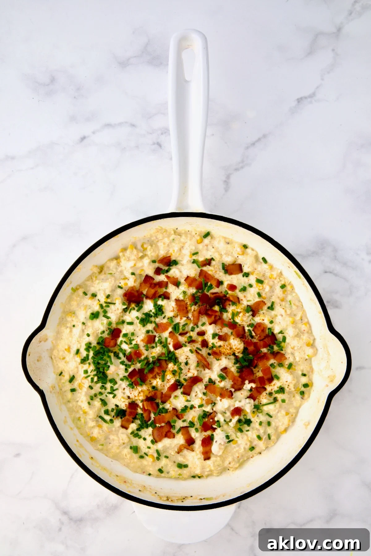 Finished smoky sweet corn puree in white enamel cast iron skillet.