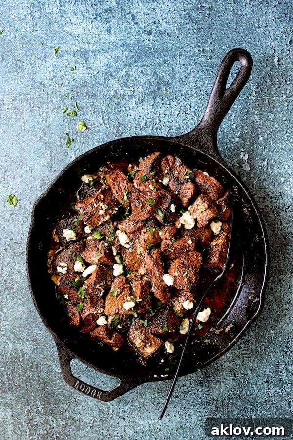 Overhead shot of Buttery Blackened Steak Bites with Gorgonzola in a cast iron skillet, ready to be served.