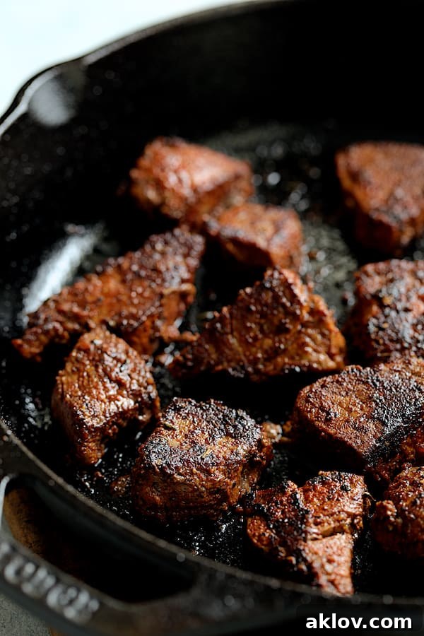 Buttery Blackened Steak Bites being browned to perfection in a cast iron skillet, showing the developing crust.