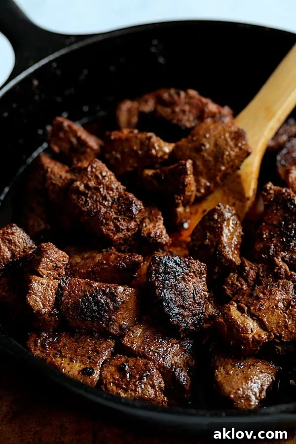 Buttery Blackened Steak Bites being gently tossed with melted butter in a cast iron skillet, creating a rich glaze.