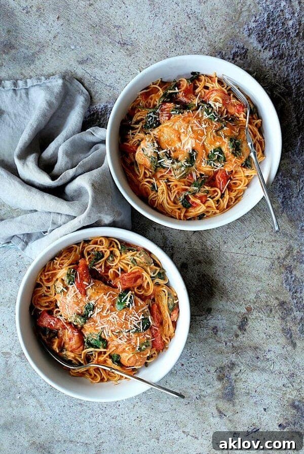 Two bowls Chicken in Rosa Sauce with Roasted Red Bell Pepper and Spinach in white serving bowls.