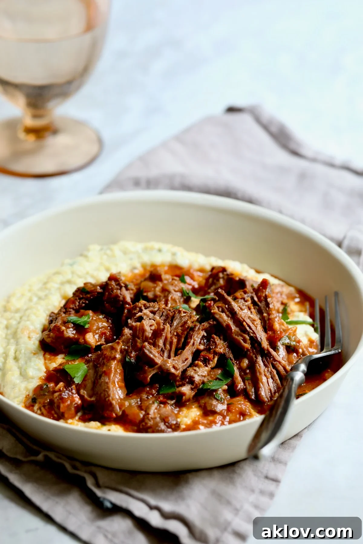 One serving of Italian Pot Roast (Stracotto) in white dinner bowl with fork.
