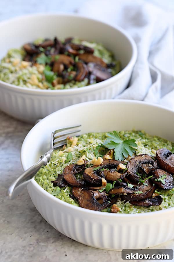 Two bowls brimming with Oven Risotto with Kale Pesto and Roasted Mushrooms, showcasing the dish's appealing presentation.