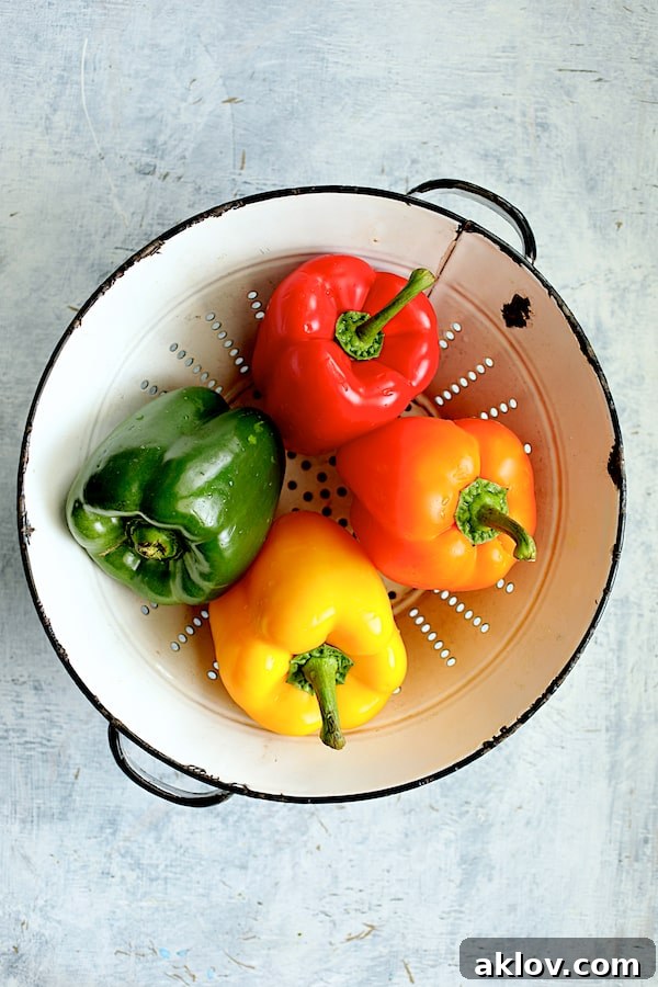 Zesty Chicken and Rice Pepper Boats 3 Photo of four bell peppers in various colors in white vintage colander.