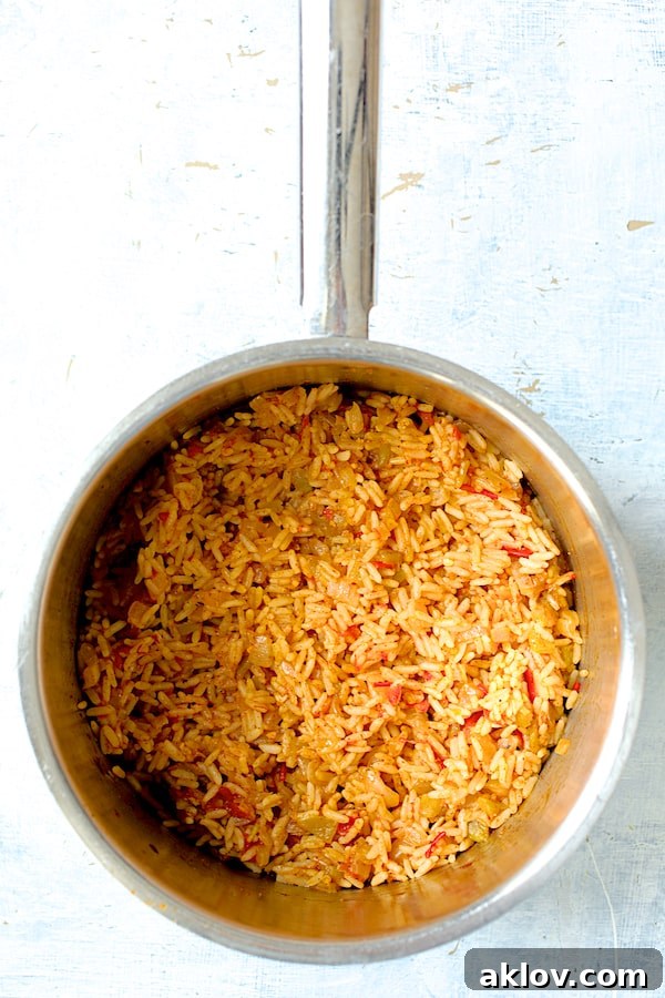 Zesty Chicken and Rice Pepper Boats 5 Photo of cooked Spanish rice in saucepan.