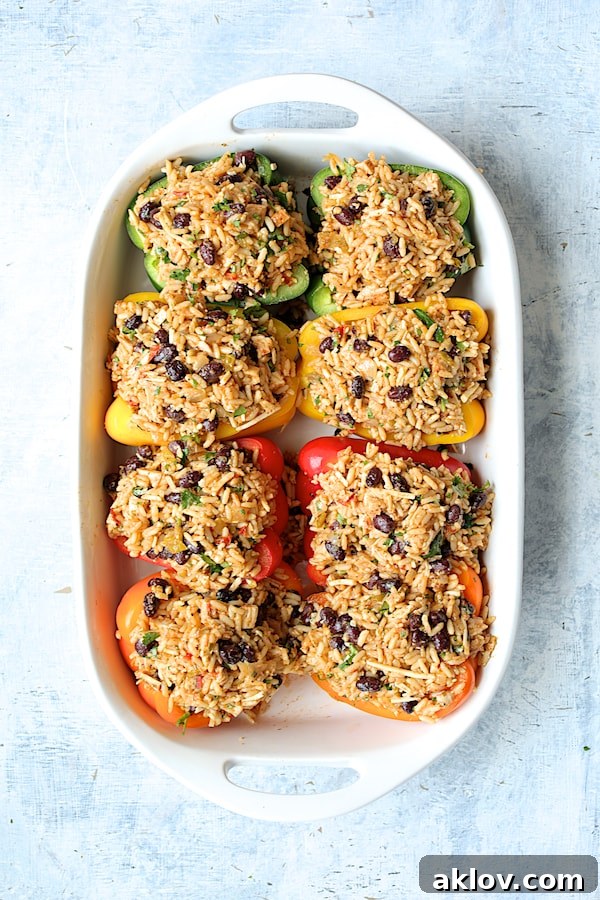 Zesty Chicken and Rice Pepper Boats 6 Photos of peppers stuffed with rice, bean and chicken combination in white baking dish.