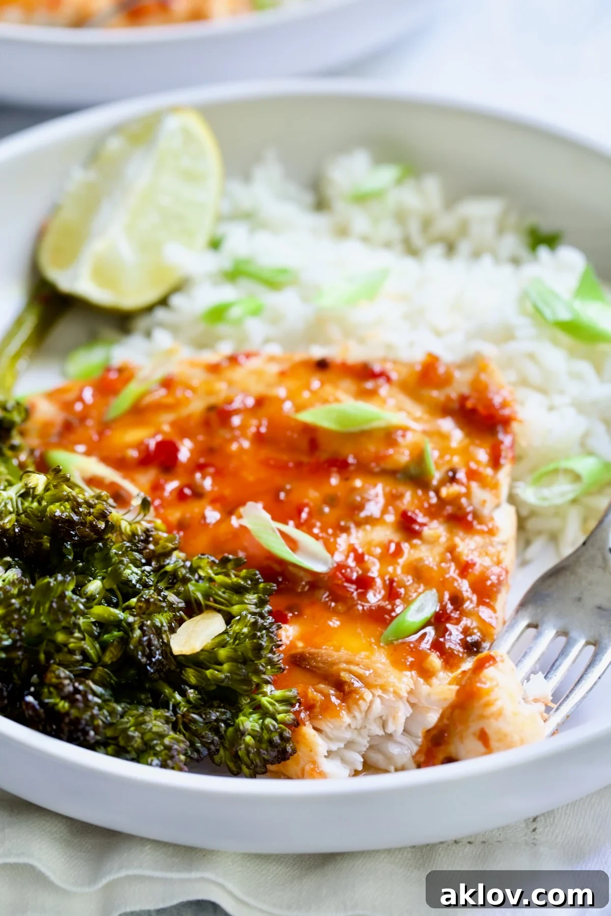 Sheet Pan Thai Baked Fish with Broccolini on white plate with fork.
