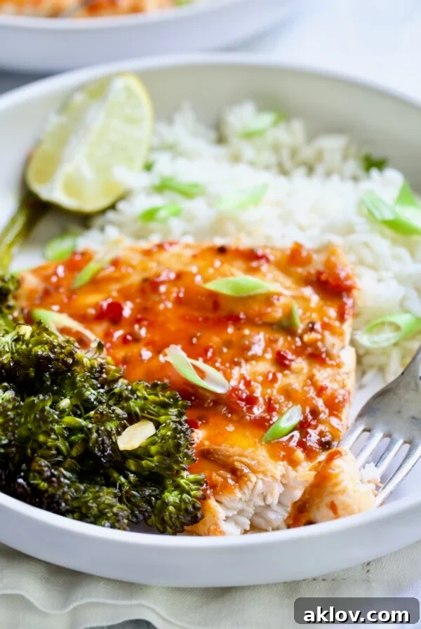 Sheet Pan Thai Baked Fish with Broccolini on white plate with fork.
