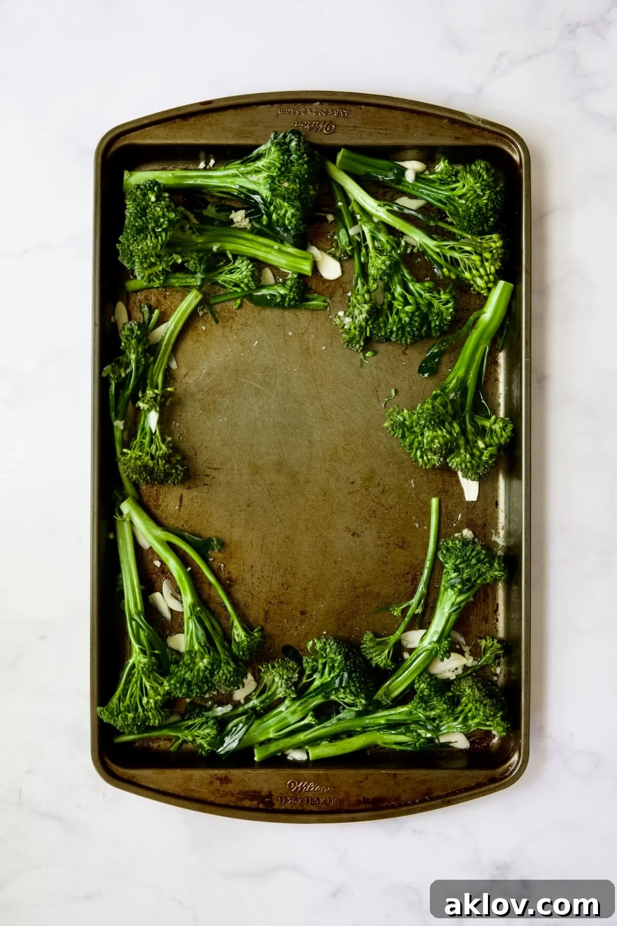 Broccolini and garlic on rimmed sheet pan.