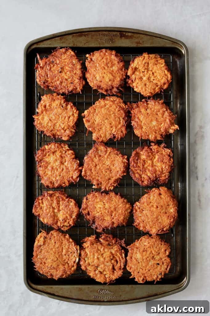Crispy Sweet Potato Latkes with Fiery Gochujang Aioli 7 Photo of fried fritters set on rack over baking sheet.