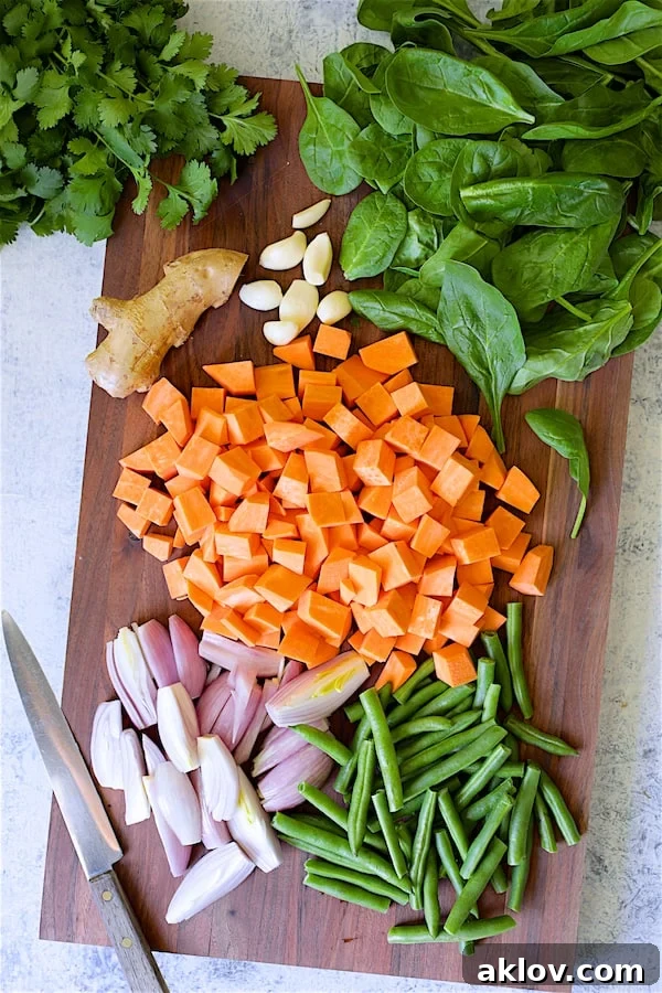Photo of fresh ingredients for Vegan Thai Sweet Potato Curry on wood cutting board.
