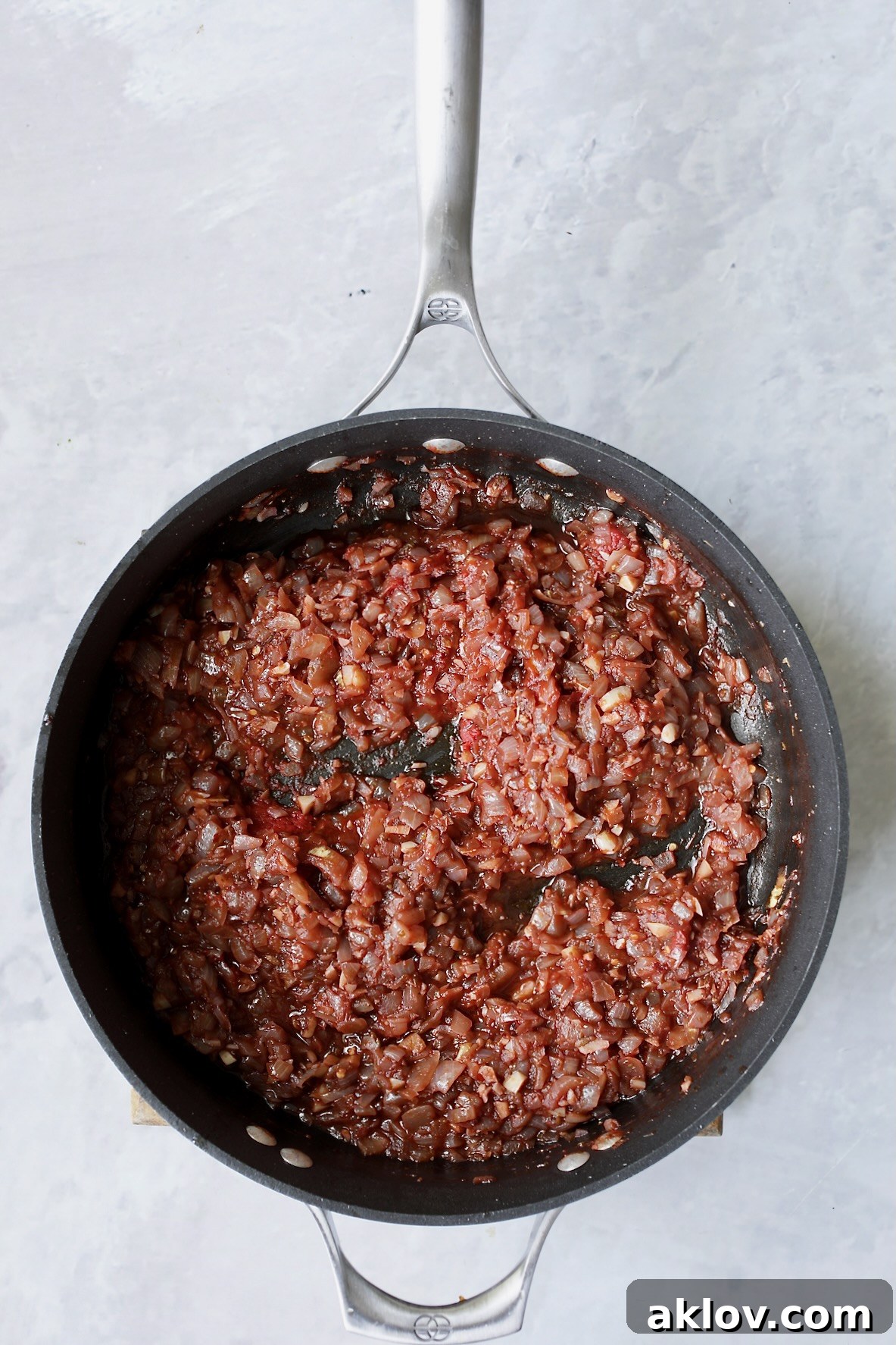 Onions in skillet with red wine that has been reduced.