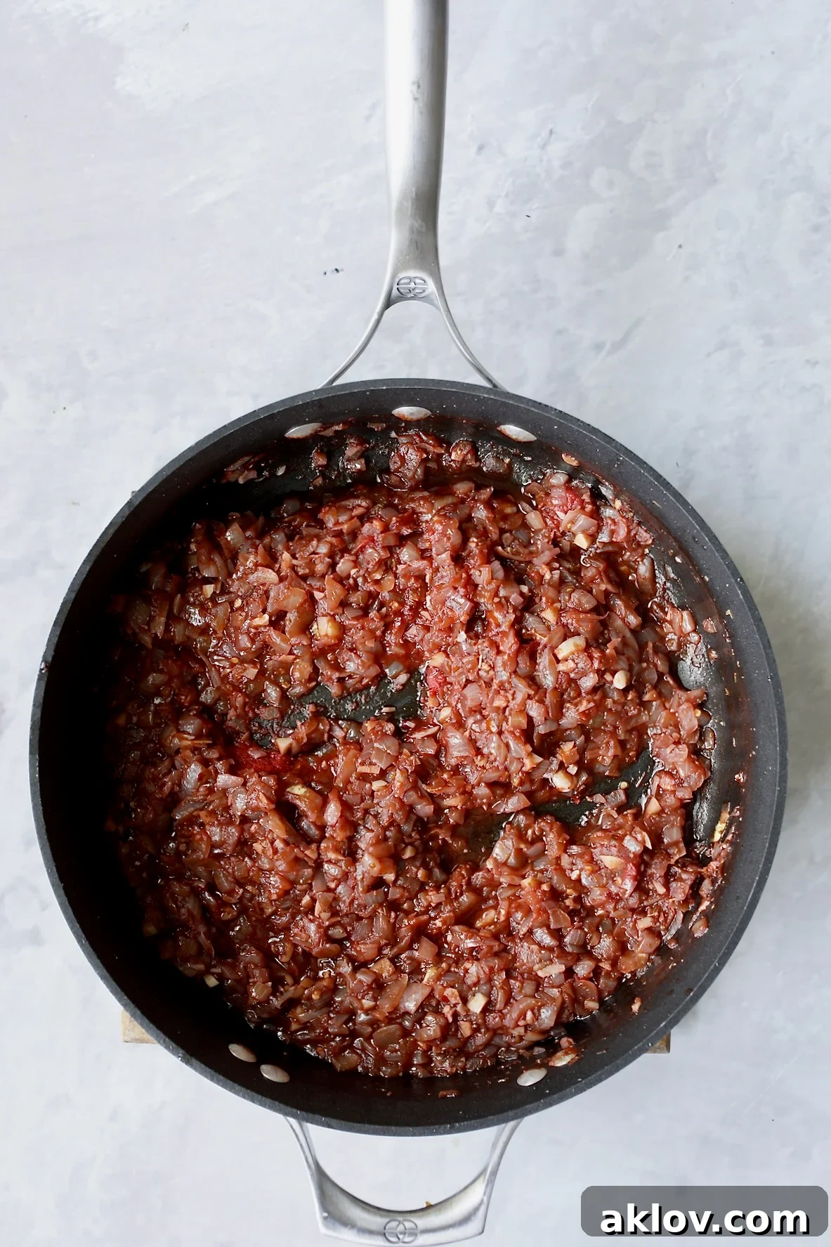 Onions in skillet with red wine that has been reduced.