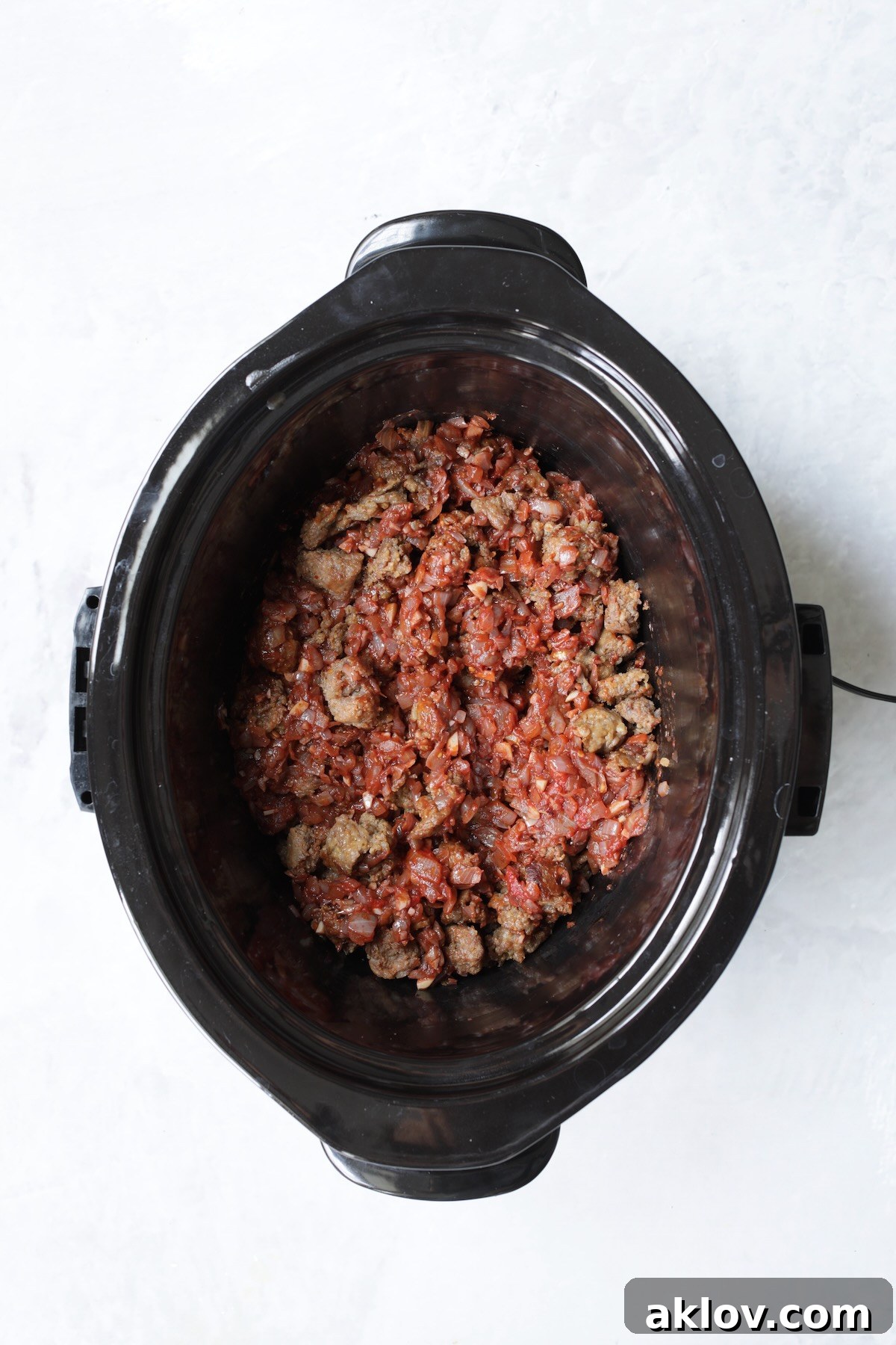 Sausage with onions and red wine in slow cooker.