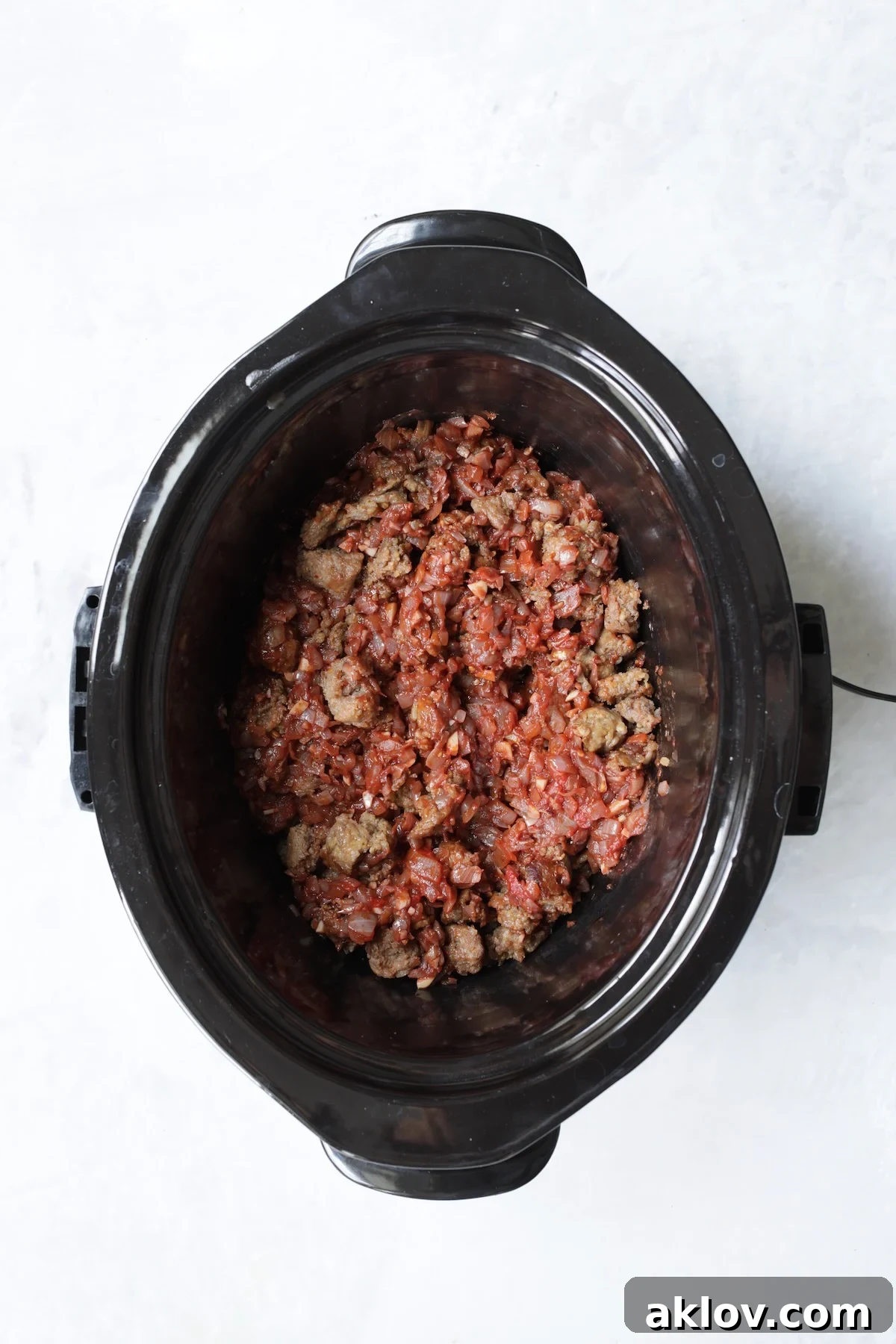 Sausage with onions and red wine in slow cooker.
