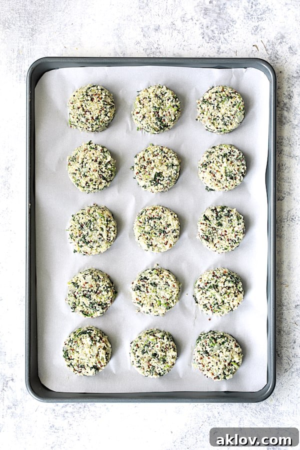 Photo of 15 quinoa cakes on parchment paper-lined baking sheet before being baked.