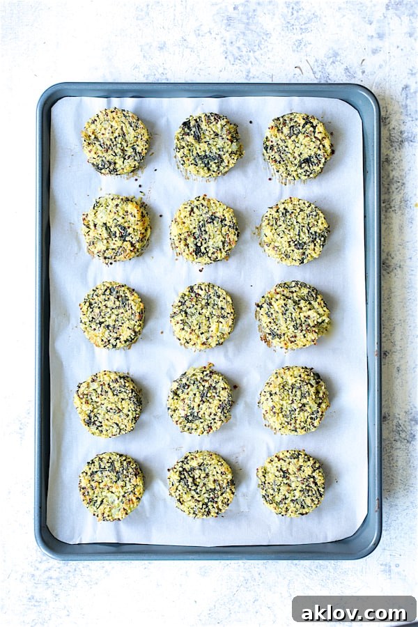 Photo of 15 baked Greek Quinoa Cakes with Tzatziki on parchment paper-lined baking sheet.