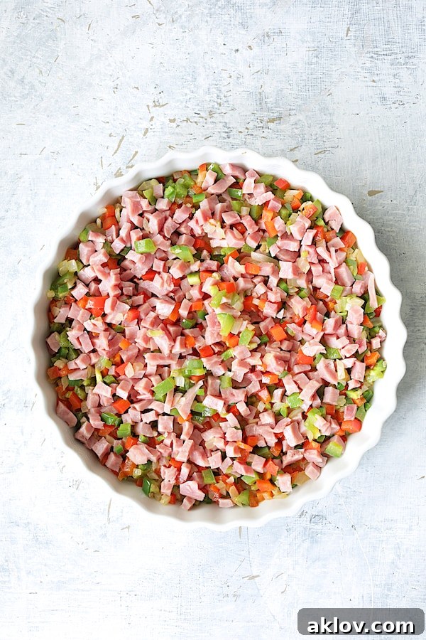 Photo of peppers and ham in round white baking dish before custard is added.