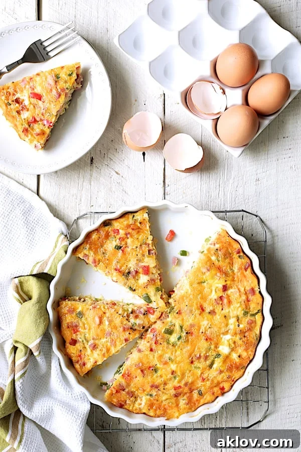 Photo of Spicy Baked Denver Omelet on cooling rack cut into pieces with eggs and eggshells nearby.