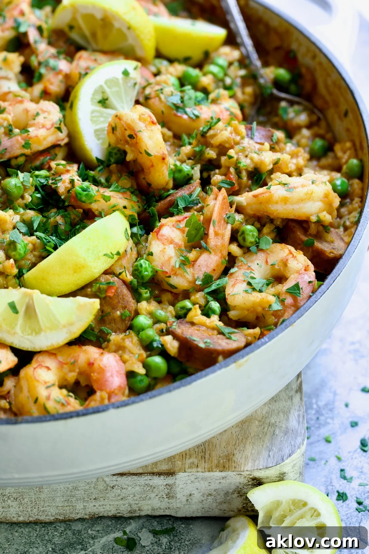 Brown Rice Paella with Shrimp and Chorizo with lemon wedges, ready for serving.