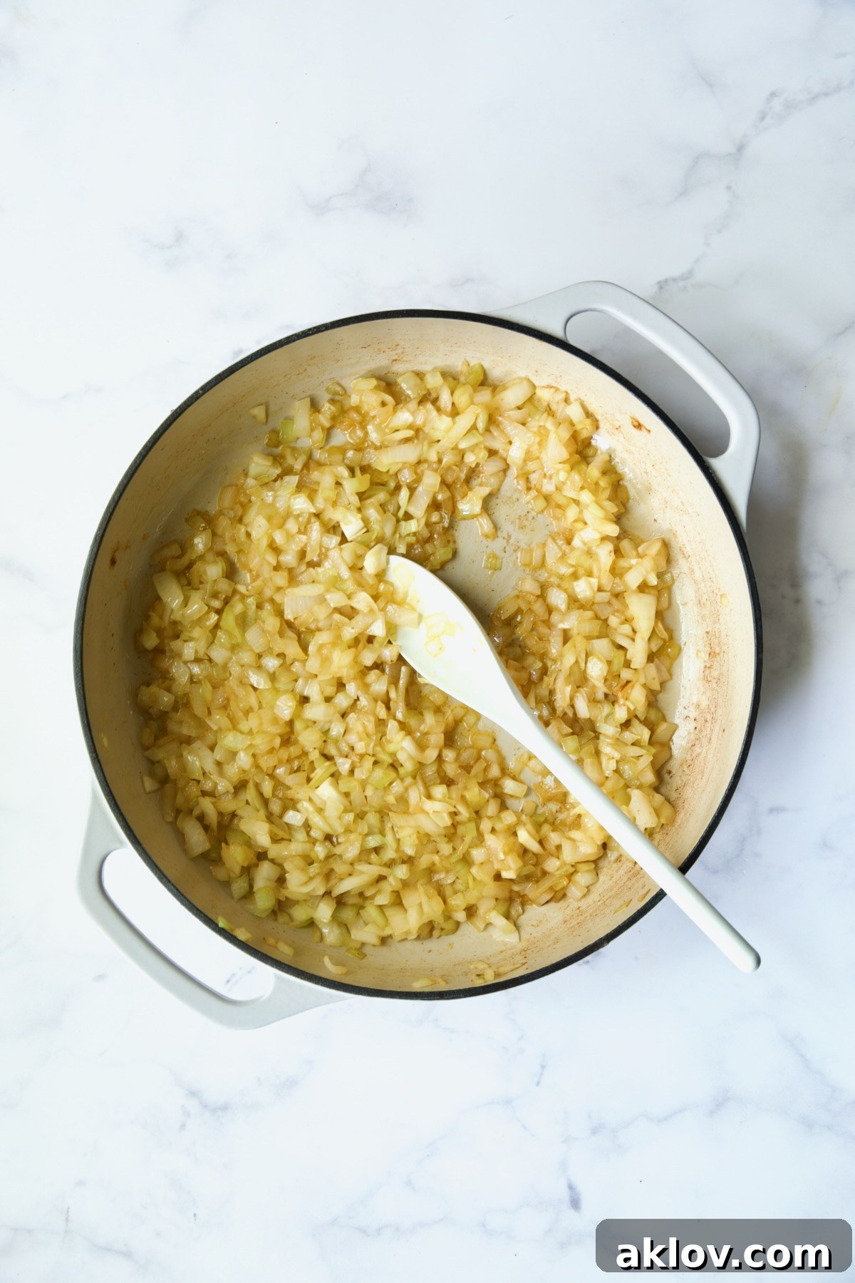 Cooked onions in white enamel cast iron skillet.